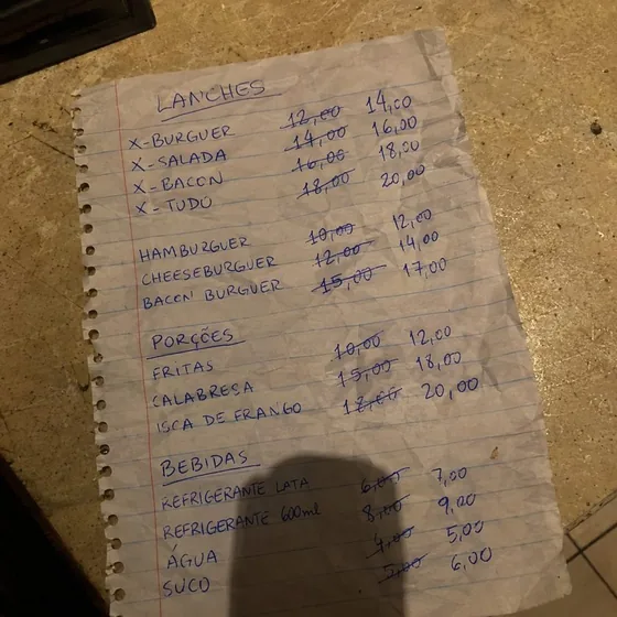 Foto de cardápio de papel escrito à mão com preços riscados